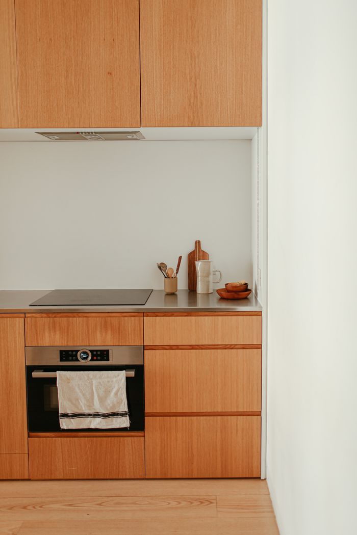 Contemporary kitchen featuring wooden cabinets and a sleek induction stove.
